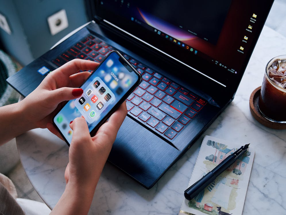 Viewer using a phone and laptop to plan how to rotate streaming subscriptions and manage monthly apps.