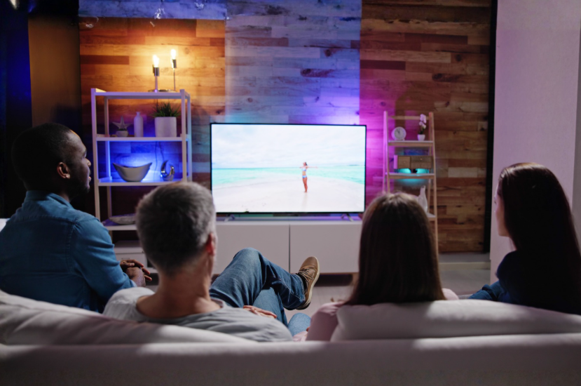 Family watching TV together with a shared streaming setup.